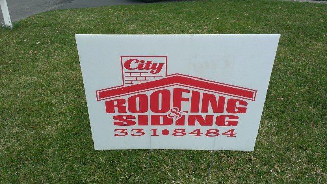 City Roofing & Siding job-site sign on a front lawn