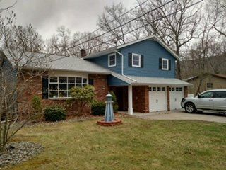 Blue vinyl siding on a ranch home with brick accents