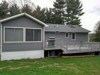 Gray vinyl siding on a split-level home with a white deck