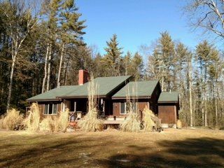 Wooded cabin with a green metal roof