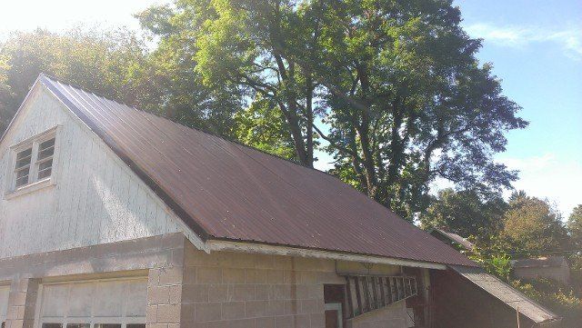 Brown metal roof on a steep gable outbuilding