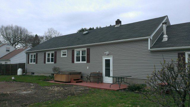 Long ranch home with new gray roof and vinyl siding