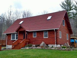 Log home with a red roof and skylights