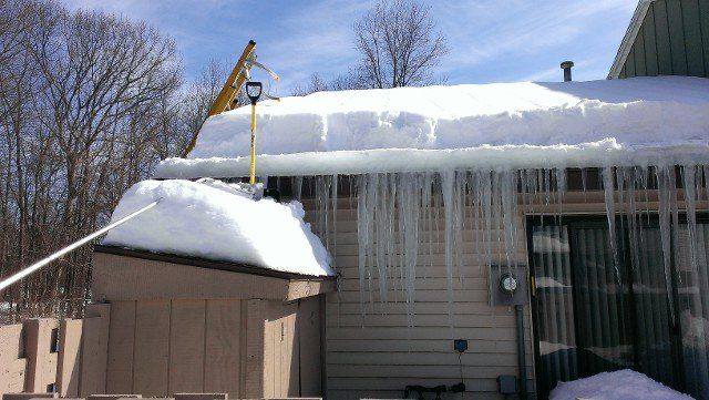 Heavy snow load and icicles along a roof edge