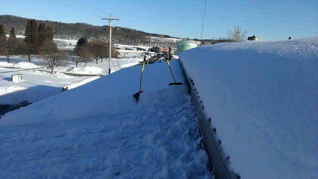 Snow-covered roof being cleared