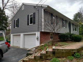 Gray vinyl siding on a raised ranch with a two-car garage